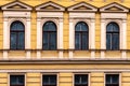 Detail of yellow art nouveau building faÃÂ§ade of four windows at renovation needed building in Riga, Latvia, Europe Royalty Free Stock Photo