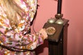 Detail of young blonde woman\'s hands, in flower dress, dialing on the dial of an antique candlestick telephone on a magenta Royalty Free Stock Photo