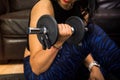 Detail young fitness woman holding dumbbell. Closeup on fitness woman workout with dumbbell at home