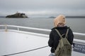 young traveler girl with backpack and camera sailing by boat to the alcatraz prison Royalty Free Stock Photo