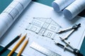 Detailed architectural blueprint of a house design is displayed with drafting tools including a ruler, pencils, compass and rolled Royalty Free Stock Photo