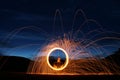 Detailed Casting fire flare steel wool night long exposure on front of hood in field with stars above
