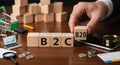 Hand places B2B cube next to B2C strategy blocks Royalty Free Stock Photo