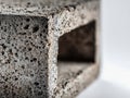 Detailed close-up of a textured grey concrete block revealing porous surface and rectangular hollow structure on a light Royalty Free Stock Photo