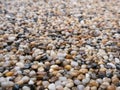 Close-up of small pebbles at an angle. Textured surface background Royalty Free Stock Photo