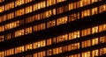 Close-up of a modern office building at night with illuminated windows showing workspaces skyscraper Royalty Free Stock Photo