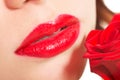 Detailed closeup of woman's red lips with rose. Royalty Free Stock Photo