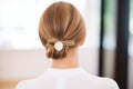 detailed golden hairpin adorning a sleek low chignon