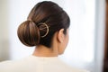 detailed golden hairpin adorning a sleek low chignon