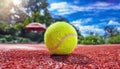 Detailed image of a paddle ball on the floor of the outdoor paddle or tennis court with a background of blue sky with clouds and Royalty Free Stock Photo