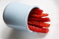 Detailed isolated copy space close up food shot of a pile of slices of fresh wet sweet red bell pepper in a blue round clay