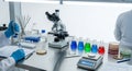 Laboratory Workbench Setup with Scientific Equipment Including Microscope, Flasks, and Petri Dishes Set Against a Bright Royalty Free Stock Photo