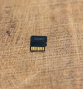 Detailed micro SD card on a wooden table. Micro SD card back side close up shot on a wooden surface. Memory card close up shot on Royalty Free Stock Photo