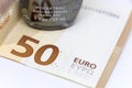 Detailed photo of a small open pocket antibacterial hand gel under a high value Euro banknote reflecting its rising price