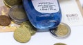 Detailed photo of a small open pocket antibacterial hand gel under a high value Euro banknote reflecting its rising price