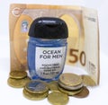 Detailed photo of a small pocket antibacterial hand gel surrounded by high value Euros