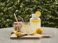 Detailed Picture of all ingredients neccesary to cook a homemade lemonade consist from water, lemon, ginger and glass of honey.