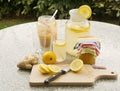 Detailed Picture of all ingredients neccesary to cook a homemade lemonade consist from water, lemon, ginger and glass of honey.