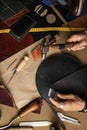 Close up of skinner craftsman working with natural leather using craft tools.