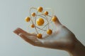 A detailed rendering of a hand holding a golden atomic model symbolizing the connection between science and human understanding Royalty Free Stock Photo