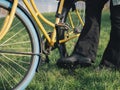 Close-up of Person Lifting Kickstand on Yellow Bicycle