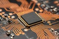 Detailed shot of a microchip embedded on a printed circuit board with intricate copper pathways connecting electronic components Royalty Free Stock Photo