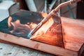 Expert carpenter burning a wood slab with a professional gas burner. Flames and smoke, fire and timber.