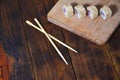 A detailed shot of a set of Japanese sushi rolls and a device for their use chopsticks, which are located on a wooden cutting b Royalty Free Stock Photo