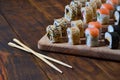 A detailed shot of a set of Japanese sushi rolls and a device for their use chopsticks, which are located on a wooden cutting b Royalty Free Stock Photo