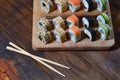 A detailed shot of a set of Japanese sushi rolls and a device for their use chopsticks, which are located on a wooden cutting b Royalty Free Stock Photo