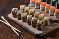 A detailed shot of a set of Japanese sushi rolls and a device for their use chopsticks, which are located on a wooden cutting b Royalty Free Stock Photo