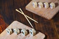 A detailed shot of a set of Japanese sushi rolls and a device for their use chopsticks, which are located on a wooden cutting b Royalty Free Stock Photo