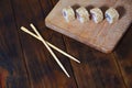 A detailed shot of a set of Japanese sushi rolls and a device for their use chopsticks, which are located on a wooden cutting b Royalty Free Stock Photo