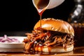 detailed shot of vinegar sauce drizzling onto pulled pork slider