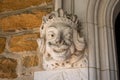 A Detailed Statue of a Face on a Cobblestone Wall at the Elkins Estate