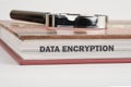 A detailed study guide on data encryption is placed on a surface alongside a magnifying glass, highlighting the Royalty Free Stock Photo