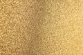 Detailed texture of glittering golden dust surface backdrop with space for text