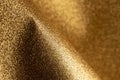Detailed texture of glittering golden dust surface backdrop with space for text