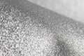 Detailed texture of glittering silver dust surface backdrop with space for text