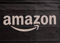 Detailed view of the Amazon wordmark and smile logo on a black textured package, symbolizing