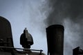 Detailed view of a black historic steam locomotive blowing black rusty smoke out of a chimney, transport, black and white Royalty Free Stock Photo