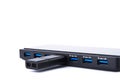 Detailed view of black USB hub with many ports, charging and flash drive with silver blue connector. On white background with