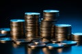 Detailed view of coin pile and stack, black background, blue filter