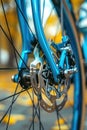 Detailed view of the front wheel of a blue bike, showing spokes, tires, and hub