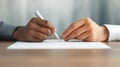 A detailed view of hands expertly signing a document, symbolizing commitment on a rustic wooden table surface Royalty Free Stock Photo
