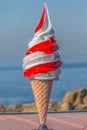 Detailed view of ice cream cone in plastic, commercial icon for ice cream seller, sea as background Royalty Free Stock Photo