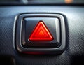 Illuminated red hazard warning triangle button on a car\'s interior dashboard light Royalty Free Stock Photo