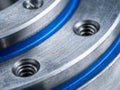 Detailed view of industrial metal components featuring threaded holes and blue rubber seals in a precision-engineered mechanical Royalty Free Stock Photo
