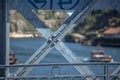 Detailed view at the metallic structure of D. Luis bridge, with painting elements, Douro river and two recreational boats as