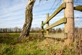 Detailed view of a newly installed timber built fence and barbed wire seen at the entrance to a farm field.